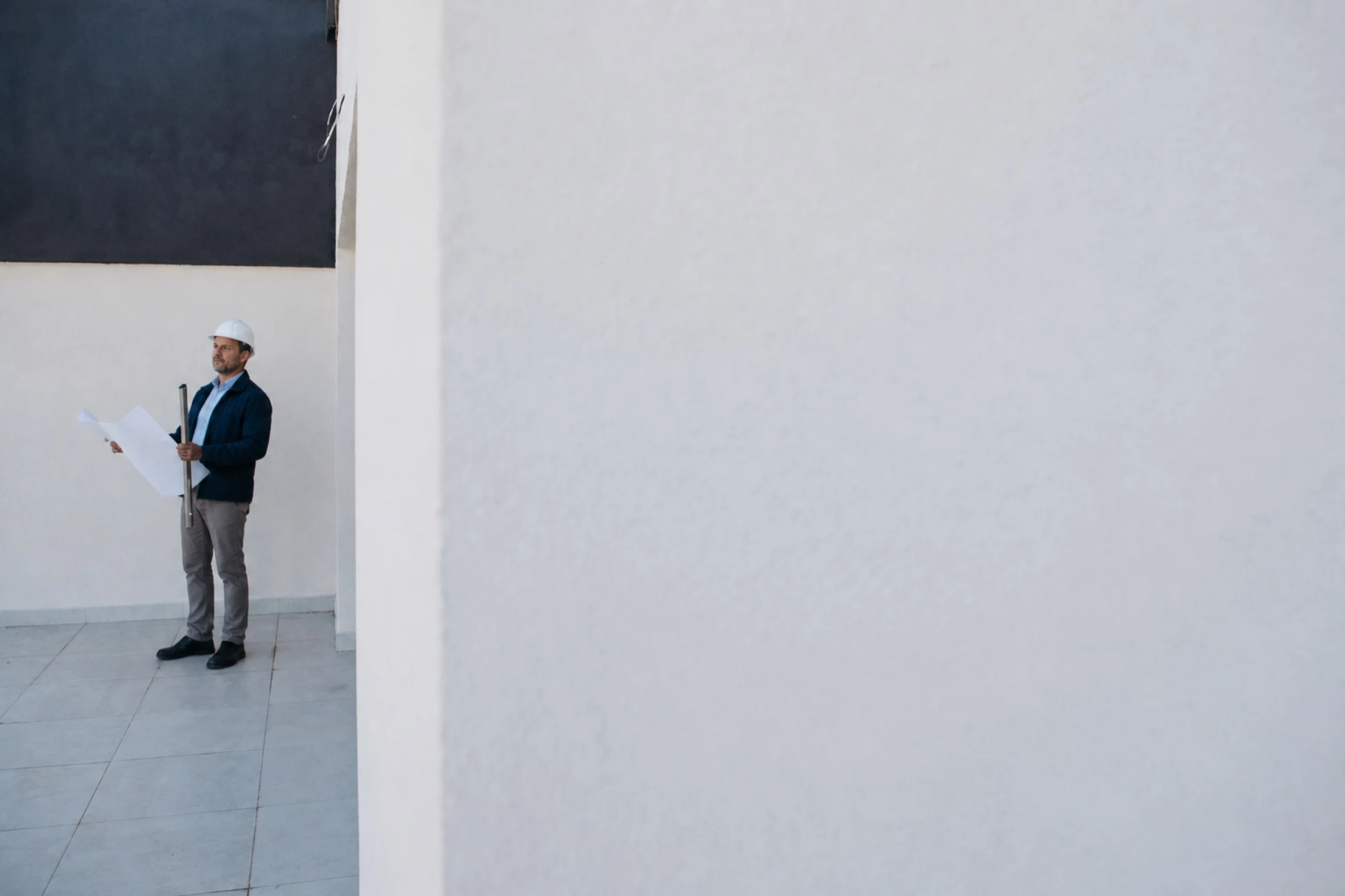Architekt prüft einen Grundriss in einem hellen Bestandsgebäude