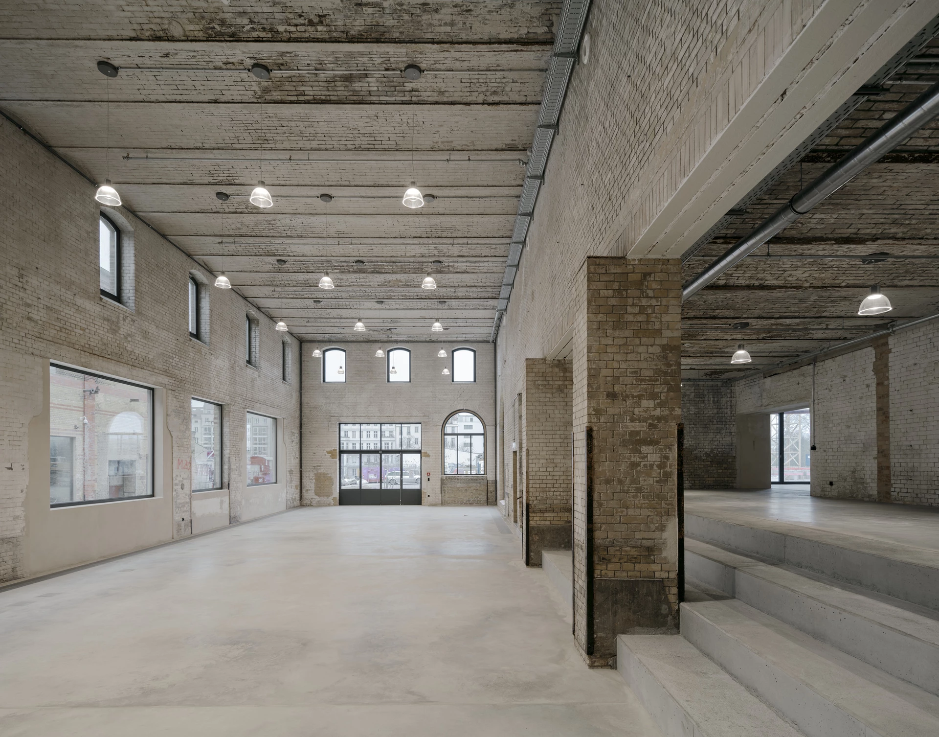 Bötzow-Brauerei in Berlin: erhaltenes Mauerwerk, Tragstruktur und neue Erschließung in einer hellen umgenutzten Halle