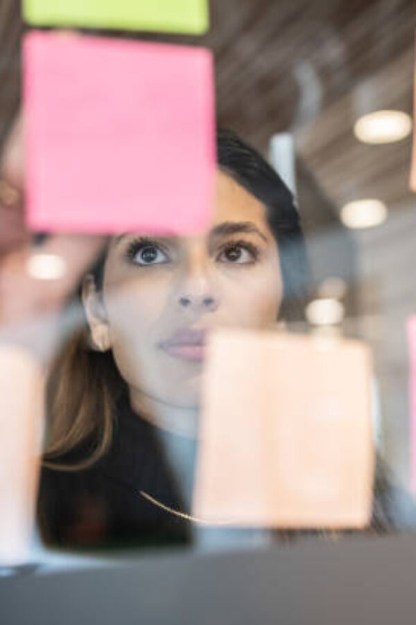 Young woman writing in post it at the office
